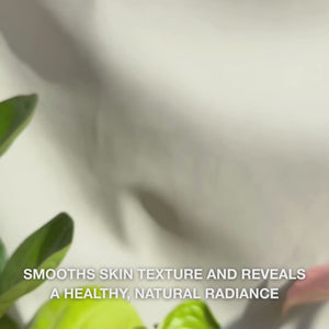 Close-up of a hand dispensing a few thin drops of translucent, lightweight Peeling Serum onto fingertips and gently massaging it into clean facial skin—its silky, fluid texture visibly dissolves dull surface cells, refines skin texture, and enhances glow with natural AHAs (Lime Pearl), Niacinamide, and Tea Tree Oil